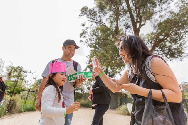 Visitors holding up and looking at a vial