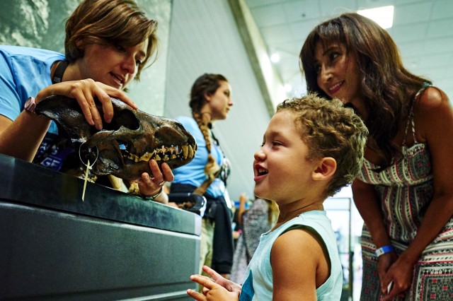 Family admiring direwolf skull with gallery interpreter at La Brea Tar Pits