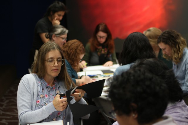 A teacher in the Tar Pits Educator Workshop: Paleo Puppetry cuts out her sabertooth-cat puppet